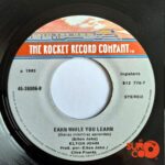 Disco de Vinilo Elton John - I’m Still Standing / Earn While You Learn Vinyl Record